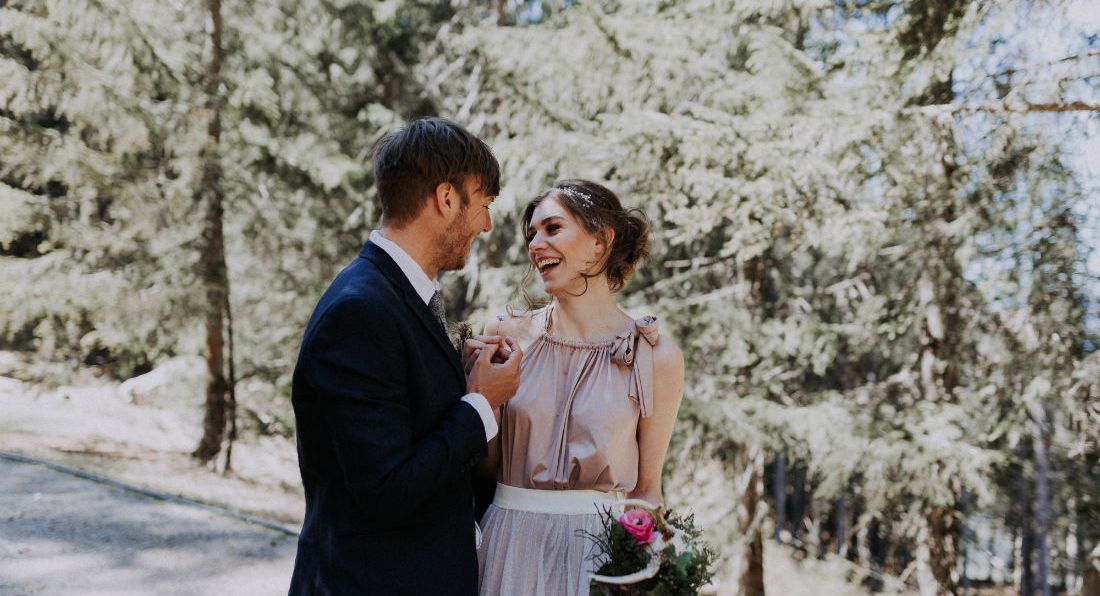 Blume wird übergeben, Dolomitenhütte, Hüttenshooting, Elopement, Hochzeit in Tirol, Braut lacht