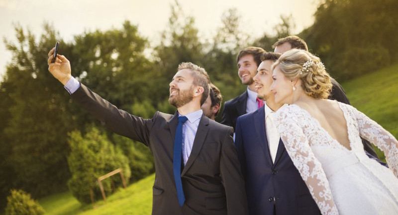 Bride with groom and his friends taking selfie