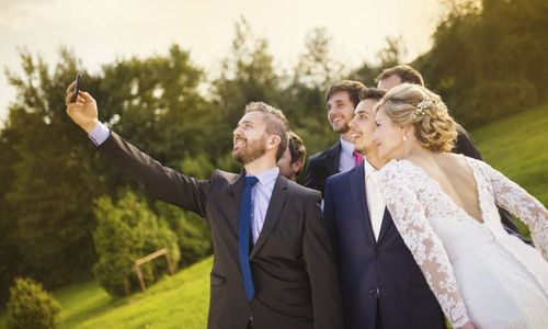 Bride with groom and his friends taking selfie